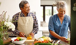 happy couple cooking healthy foods in the kitchen