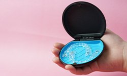 aligners in their case with a pink background