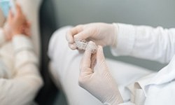 dentist’s hands hold a set of Invisalign aligners