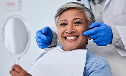 smiling woman with the dentist behind her