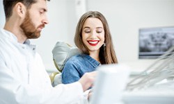 Smiling patient talking to her dentist